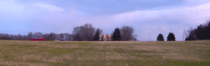 Historic house in field with cloudy skies