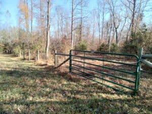 Farmgate and fence run alongside wooded area of Cherrywood in Hanover County, Virginia