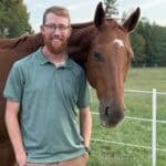 Connor Almond stands by his horse on his farm in Amelia County