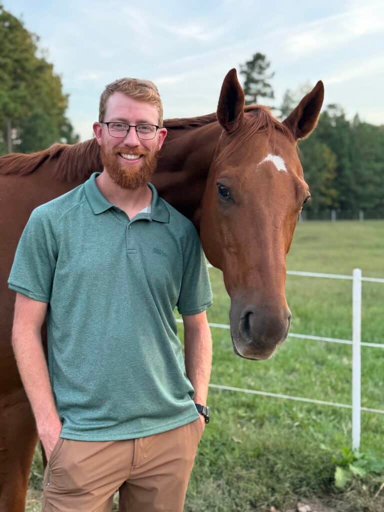 Connor Almond stands by his horse on his farm in Amelia County