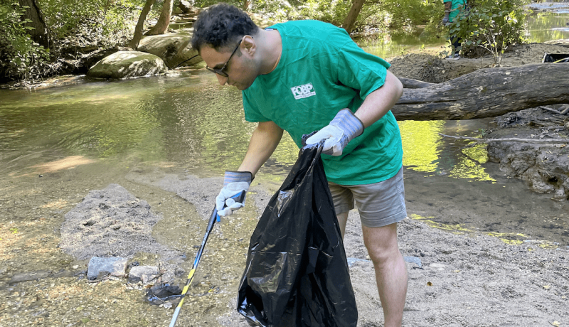 Volunteer picks up trash at Bryan Park Clean-Up.